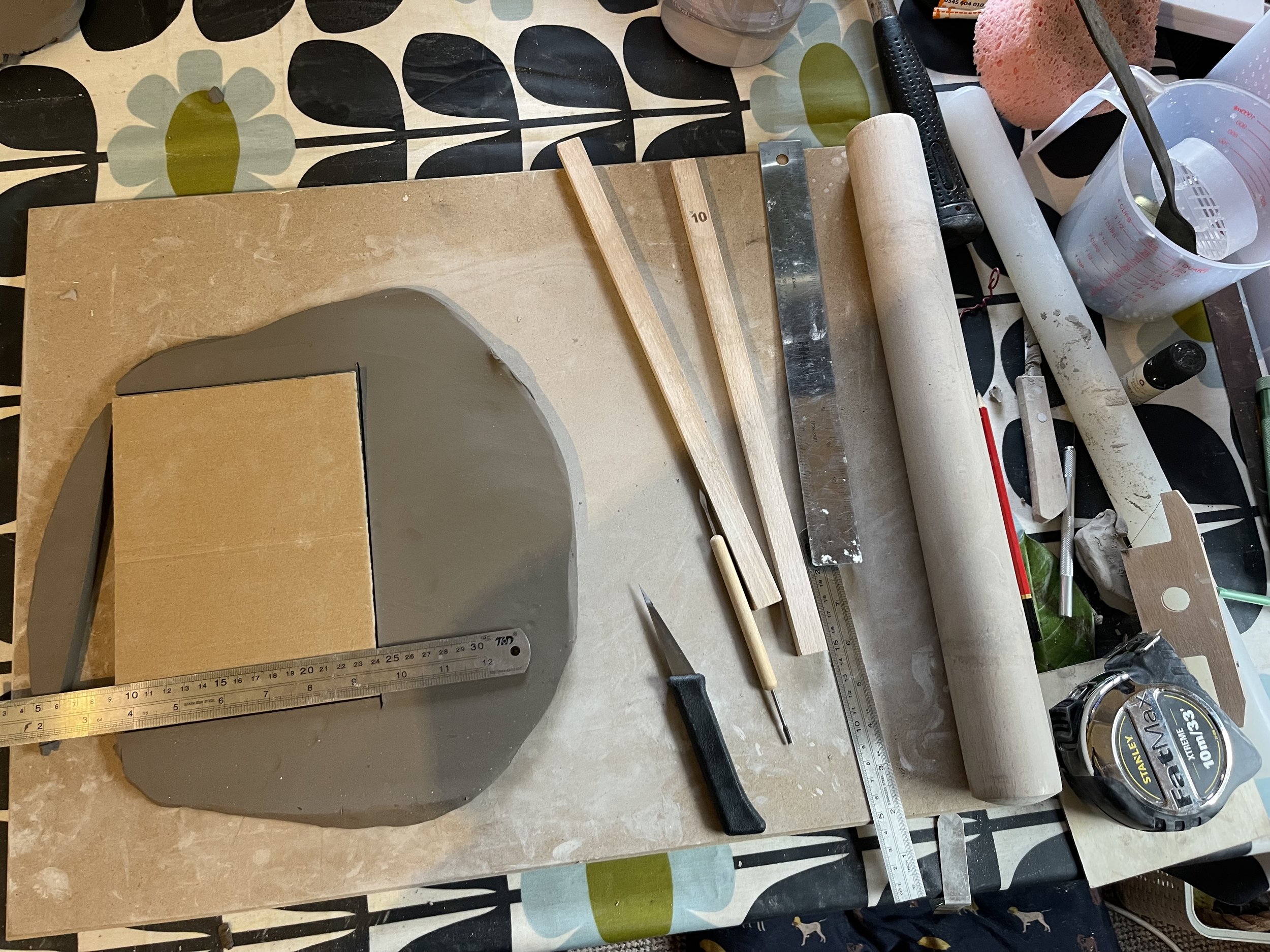 The brief was to create slab forms that could be sharp and angular as well as been softer and more organic.I stated by rolling out clay and letting it become leather hard before I could start constructing forms. 