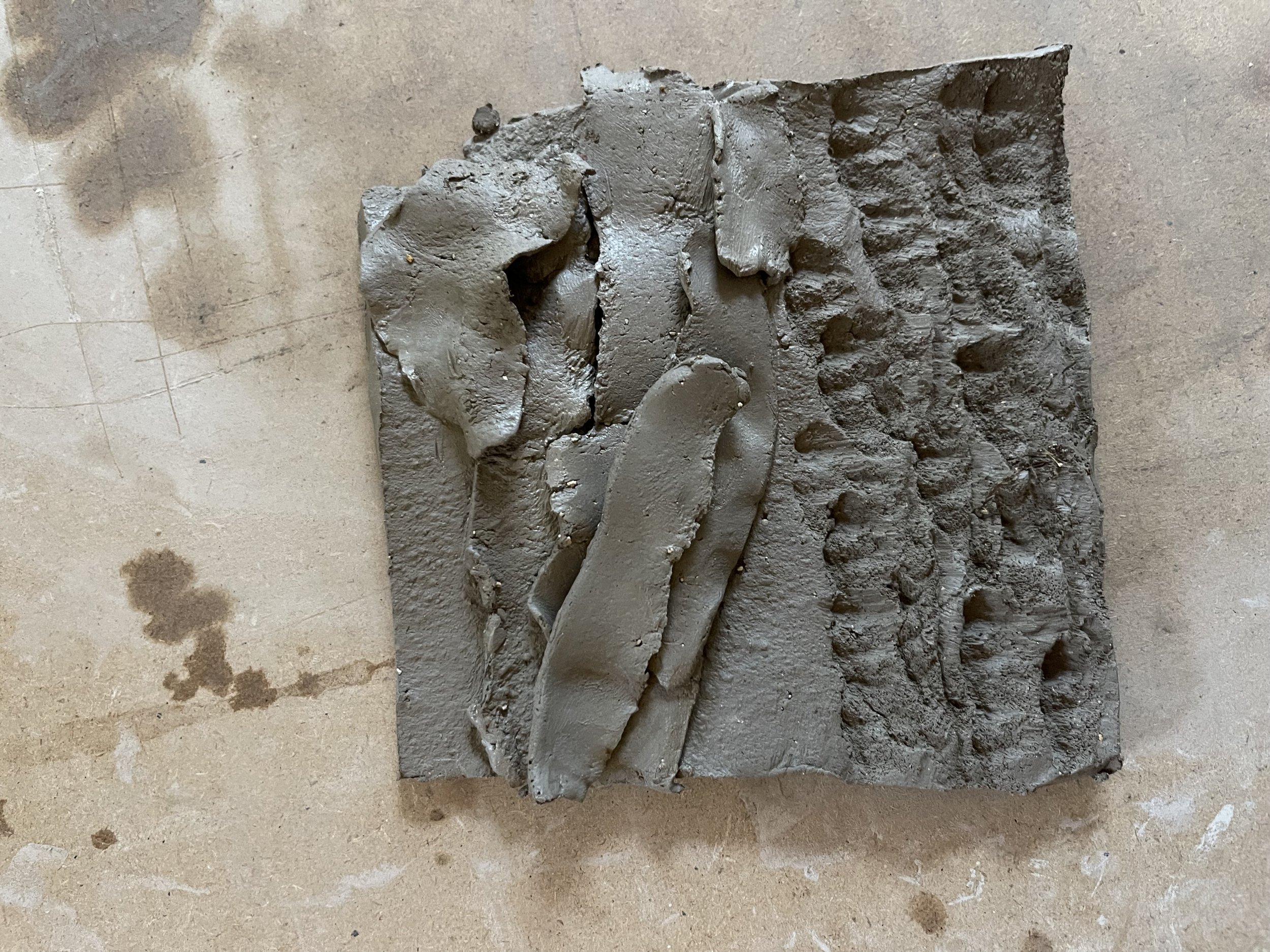  Laying on strips of clay them pressing a nut into the surface added  dimension to the surface so it appeared organic but man made at the same time and feelings of calm and confusion. 
